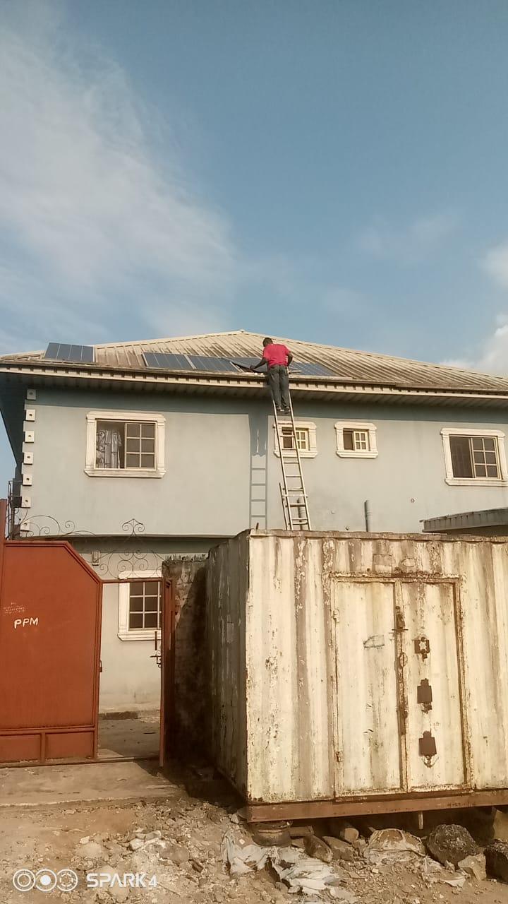 A man on a Ladder installing solar panels in the roof of a house in Ubogo, Udu L.g.a, Warri, Delta State